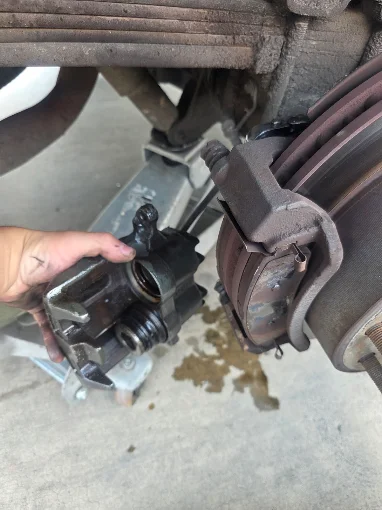 Brake caliper removed beside a brake assembly during service