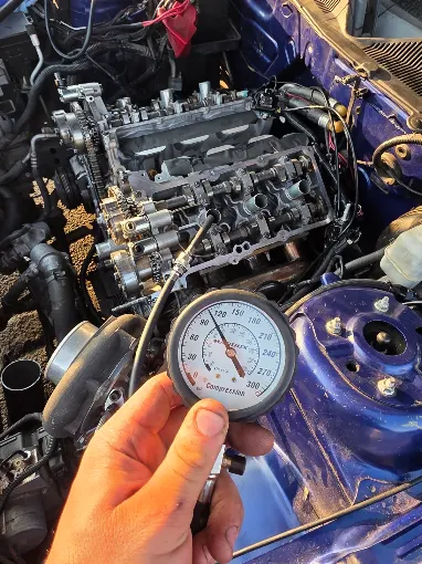 Diagnostic gauge held over an open engine bay
