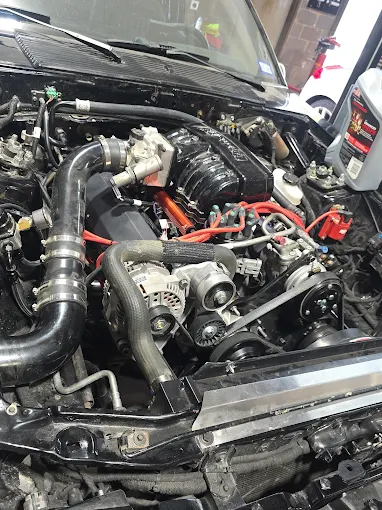 Open black vehicle engine bay during mechanical work