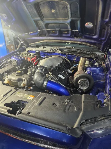 Blue engine bay with intake and engine components exposed