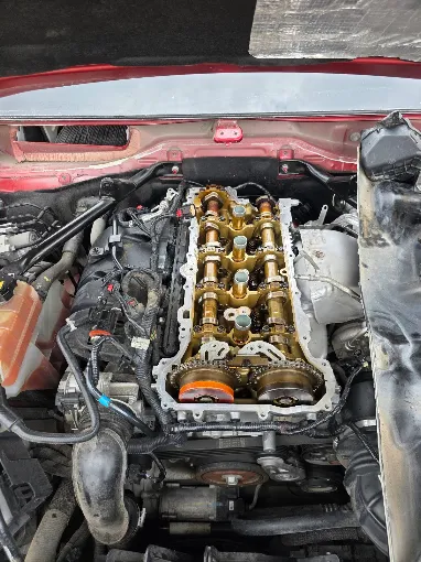 Open red vehicle engine bay during mechanical work